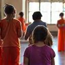 Grupo de niños y adolescentes riendo en una clase de teatro